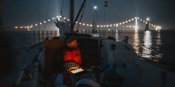 En sejler på vandet om natten natsejlads